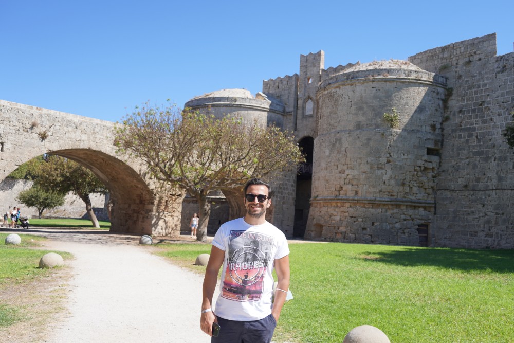 Ein Mann steht vor einer Burg in Rhodos.