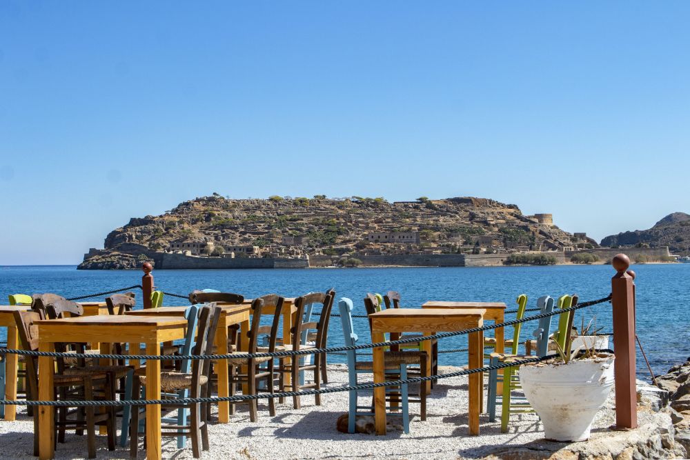 Ein Restaurant mit Tischen und Stühlen, das den Blick auf das Meer bietet. Athen Sehenswürdigkeiten.